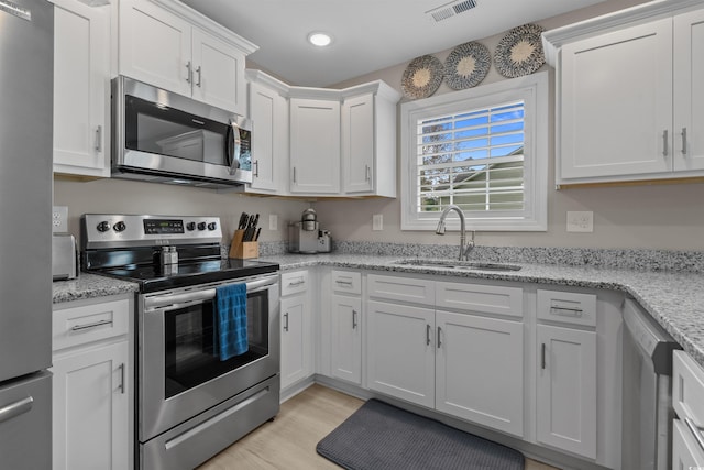 1307 Collins Park St, Conway, SC 29526 - kitchen with appliances with stainless steel finishes, a sink, white cabinetry, recessed lighting, and light wood finished floors