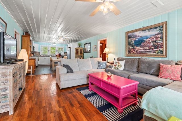 living area with ceiling fan and dark wood-type flooring