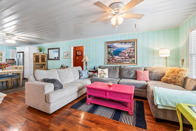 living area featuring ceiling fan, wood-type flooring, and healthy amount of natural light