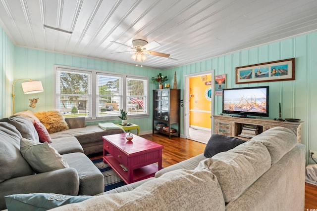 living area with wood finished floors, a ceiling fan, and baseboards