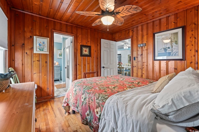 bedroom with wooden walls, wood ceiling, light wood-style flooring, and crown molding