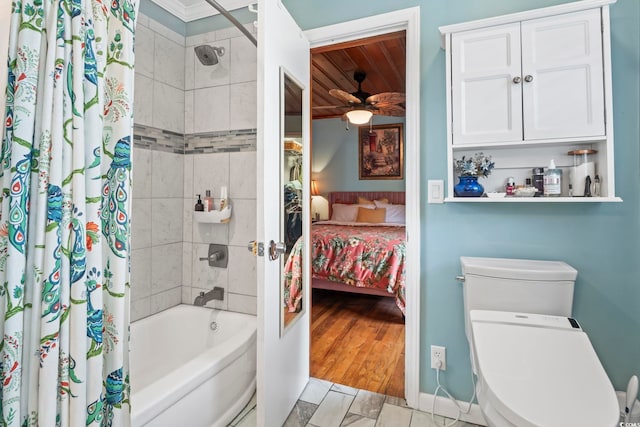 full bath with shower / tub combo, connected bathroom, toilet, and a ceiling fan