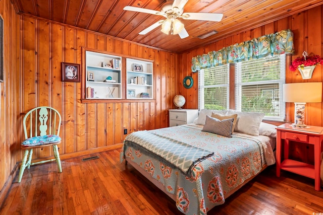 bedroom with wooden walls, wooden ceiling, and hardwood / wood-style flooring