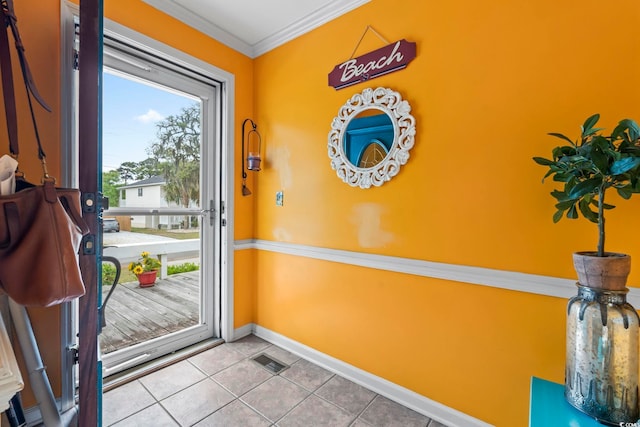 doorway featuring baseboards, tile patterned flooring, and crown molding