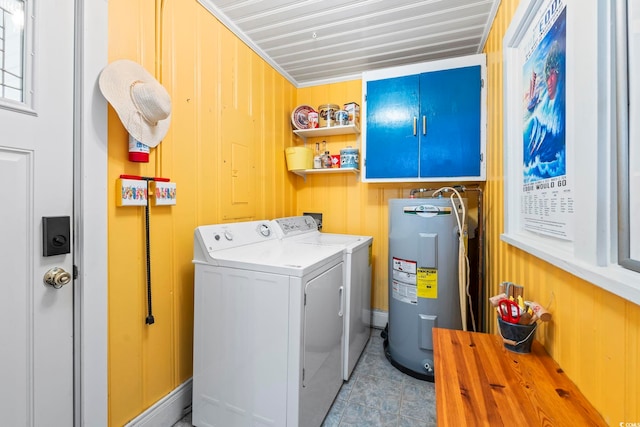 washroom featuring electric water heater, washer and dryer, light tile patterned floors, and wooden walls