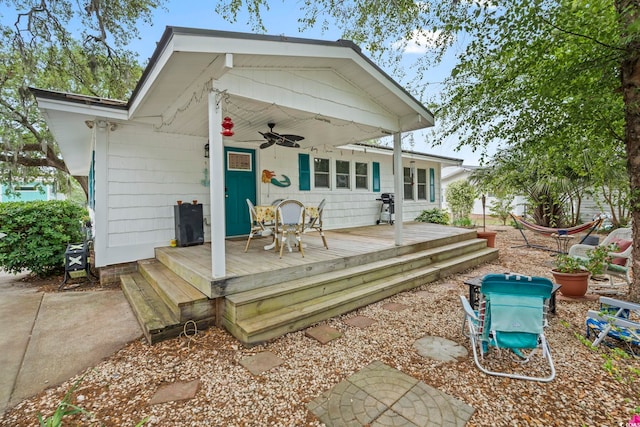 back of property featuring ceiling fan and a deck