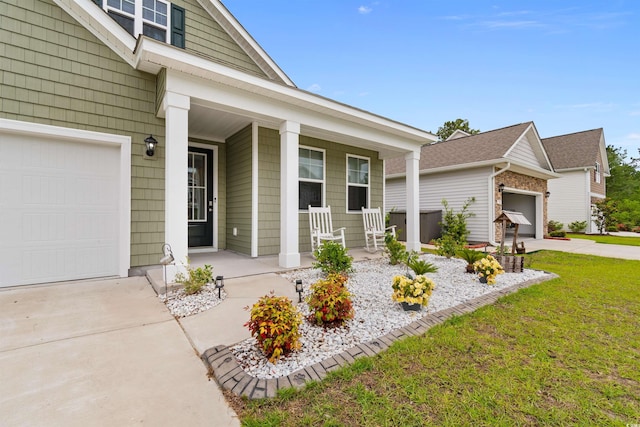 736 Flowering Branch Ave, Little River, SC 29566 - view of exterior entry with covered porch, concrete driveway, a garage, and a yard