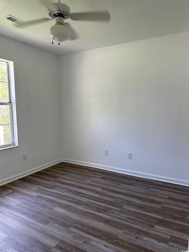 spare room with dark wood-style flooring, ceiling fan, and baseboards
