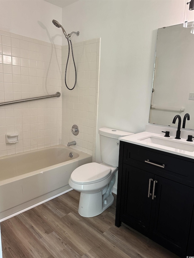 full bathroom featuring wood finished floors, toilet, bathing tub / shower combination, and vanity
