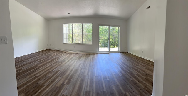spare room with dark wood-style floors, baseboards, and lofted ceiling