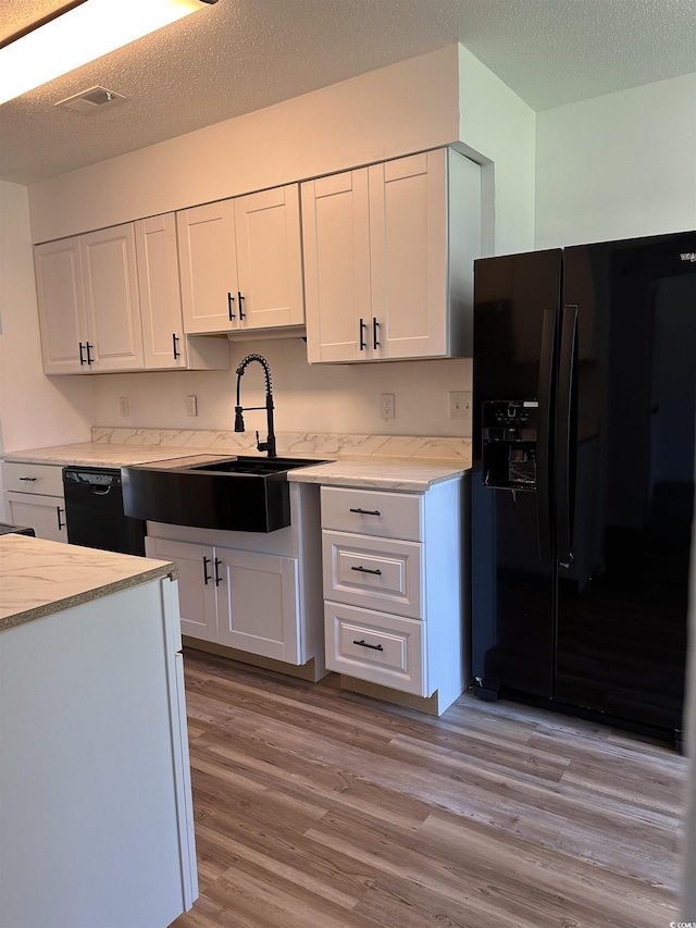 kitchen with black appliances, a sink, white cabinetry, and a textured ceiling