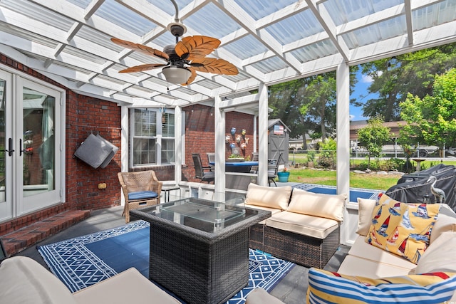 sunroom / solarium with an outdoor hangout area, ceiling fan, and french doors