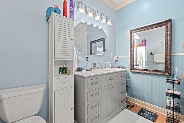 bathroom featuring crown molding, wood finished floors, vanity, and toilet