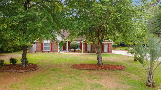 obstructed view of property with a front yard and brick siding
