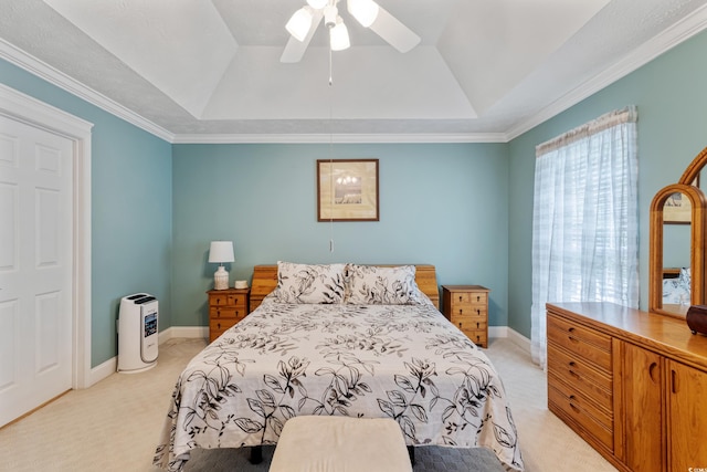 bedroom with light carpet, a tray ceiling, a ceiling fan, and crown molding