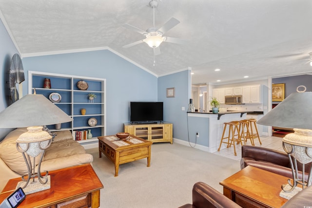 living area with crown molding, a ceiling fan, lofted ceiling, light colored carpet, and a textured ceiling