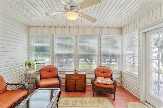 sunroom / solarium with tile patterned floors, a ceiling fan, and healthy amount of natural light