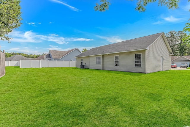 back of property featuring central AC unit and a shingled roof