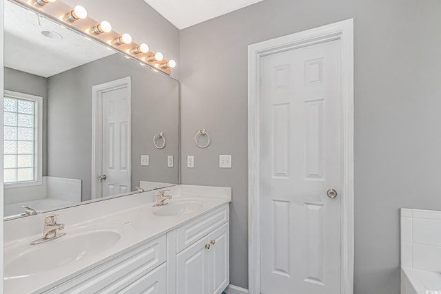 bathroom with a bath and double vanity
