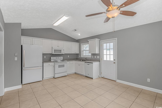 kitchen featuring white appliances, a sink, lofted ceiling, white cabinetry, and a textured ceiling
