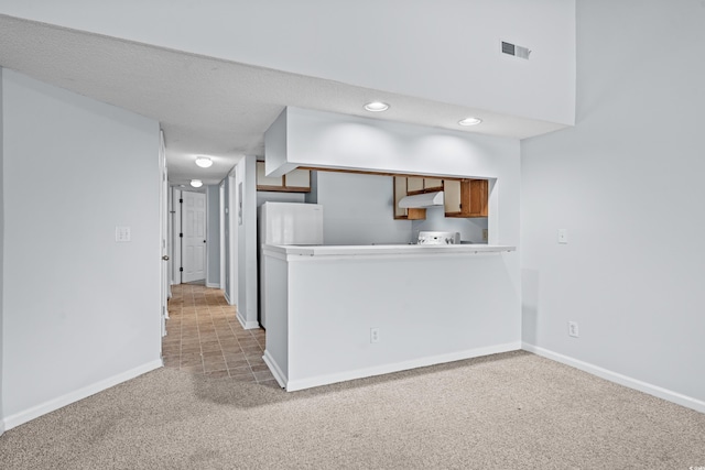 1100 Possum Trot Rd Unit B202, North Myrtle Beach, SC 29582 - kitchen featuring light colored carpet, baseboards, under cabinet range hood, brown cabinetry, and recessed lighting