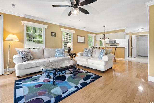 living area featuring crown molding, light wood finished floors, ceiling fan, and baseboards