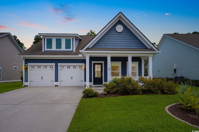 306 Southgate Ct, Pawleys Island, SC 29585 - view of front of house featuring driveway, a yard, covered porch, an attached garage, and roof with shingles