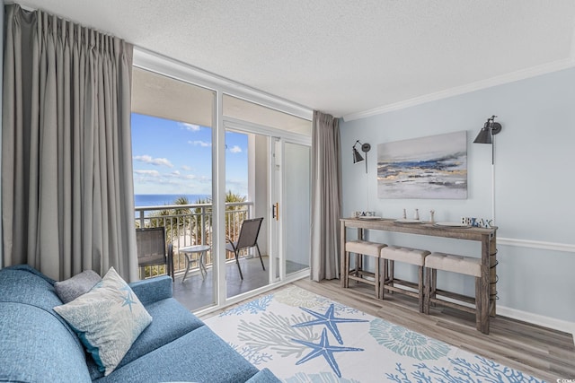 2000 N Ocean Blvd Unit 315, Myrtle Beach, SC 29577 - living room featuring expansive windows, wood finished floors, a textured ceiling, a water view, and crown molding