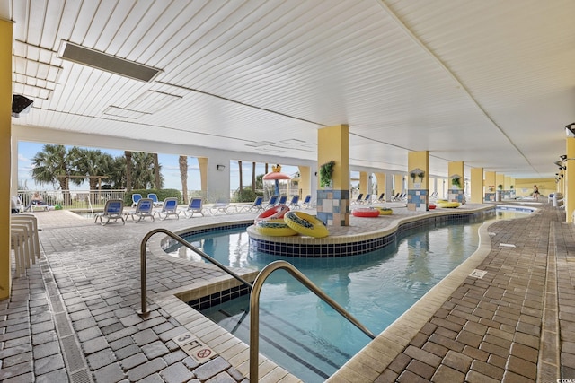 indoor community pool with a patio area and fence