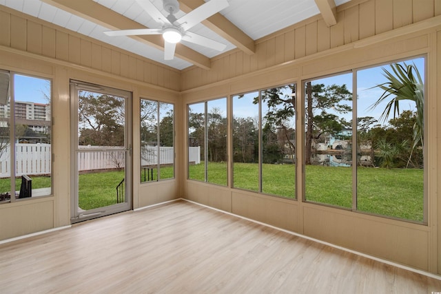 unfurnished sunroom with a ceiling fan, beamed ceiling, a skylight, and plenty of natural light