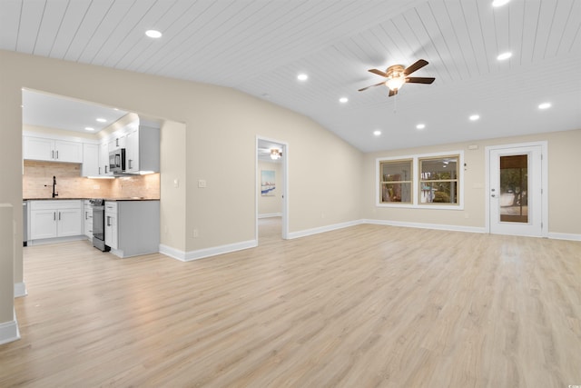 unfurnished living room with a ceiling fan, a sink, recessed lighting, light wood finished floors, and baseboards