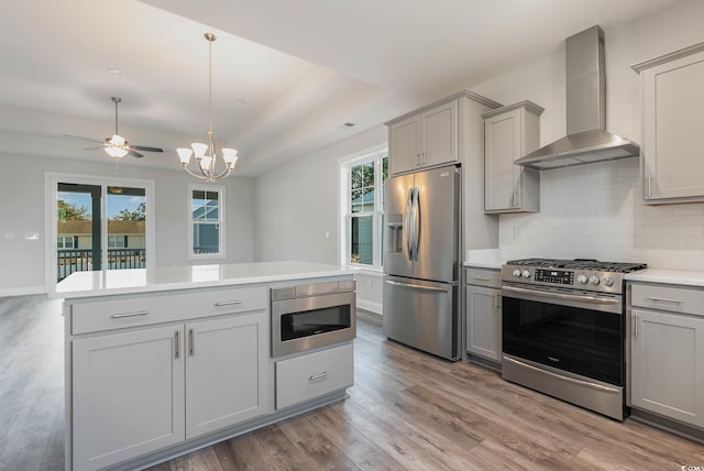 61 Yale Pl, Pawleys Island, SC 29585 - kitchen with stainless steel appliances, gray cabinets, wall chimney exhaust hood, decorative backsplash, and light countertops