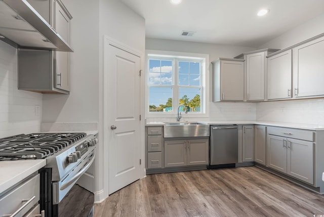 61 Yale Pl, Pawleys Island, SC 29585 - kitchen with gray cabinetry, appliances with stainless steel finishes, a sink, wall chimney range hood, and recessed lighting