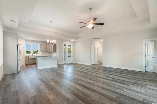 61 Yale Pl, Pawleys Island, SC 29585 - unfurnished living room with a tray ceiling, a chandelier, ceiling fan, dark wood-style floors, and baseboards
