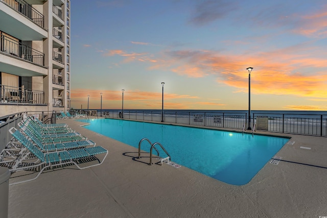 1690 N Waccamaw Dr Unit 103, Garden City Beach, SC 29576 - pool at dusk with a community pool, a water view, and fence