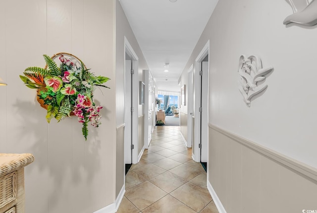 1690 N Waccamaw Dr Unit 103, Garden City Beach, SC 29576 - hall featuring light tile patterned flooring, a decorative wall, and a wainscoted wall