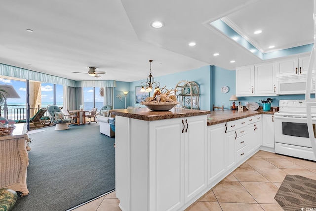 1690 N Waccamaw Dr Unit 103, Garden City Beach, SC 29576 - kitchen featuring white appliances, a peninsula, white cabinetry, light tile patterned flooring, and a ceiling fan