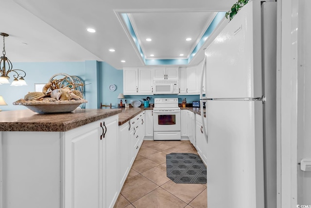 1690 N Waccamaw Dr Unit 103, Garden City Beach, SC 29576 - kitchen with white appliances, dark countertops, a peninsula, white cabinetry, and light tile patterned floors