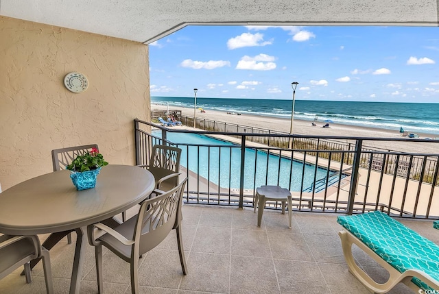1690 N Waccamaw Dr Unit 103, Garden City Beach, SC 29576 - balcony featuring view of water and beach, a patio area, and view of pool area