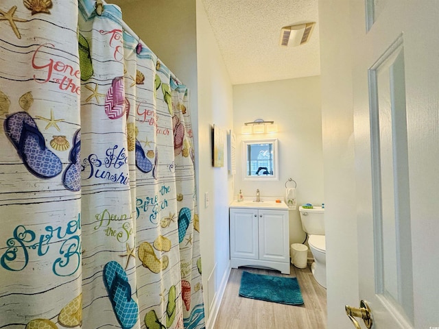 4783 Wild Iris Dr Unit 101, Myrtle Beach, SC 29577 - bathroom featuring toilet, wood finished floors, vanity, a textured ceiling, and a shower with curtain