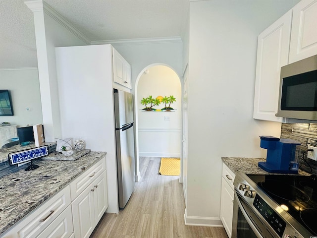 4783 Wild Iris Dr Unit 101, Myrtle Beach, SC 29577 - kitchen with stainless steel appliances, ornamental molding, light wood-style floors, light stone countertops, and white cabinets