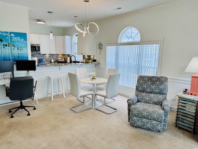 4783 Wild Iris Dr Unit 101, Myrtle Beach, SC 29577 - dining space featuring light carpet, ornamental molding, and a textured ceiling