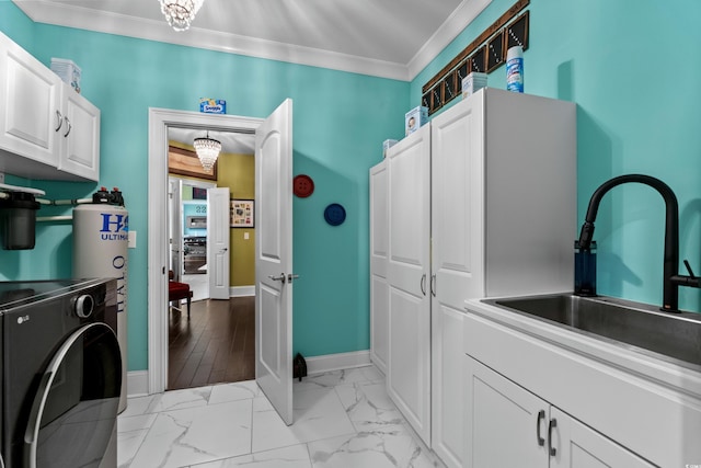 washroom featuring cabinet space, washer / dryer, ornamental molding, baseboards, and light marble finish floors