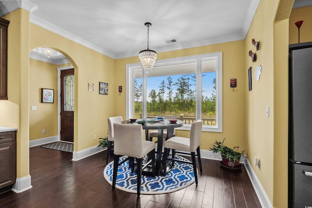 dining room featuring arched walkways, dark wood-style floors, crown molding, baseboards, and a chandelier