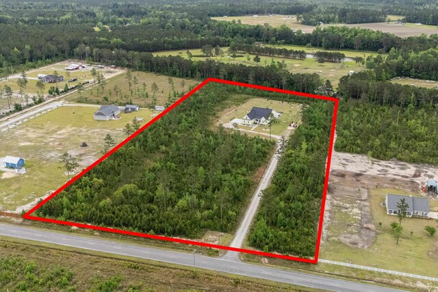 overview of rural landscape with property parcel outlined and a forest