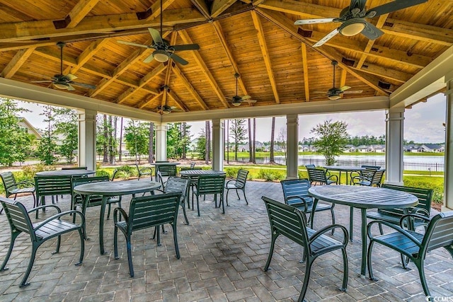 view of patio / terrace with ceiling fan, a gazebo, a water view, and outdoor dining area