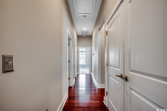 hall featuring attic access, dark wood-style floors, and baseboards