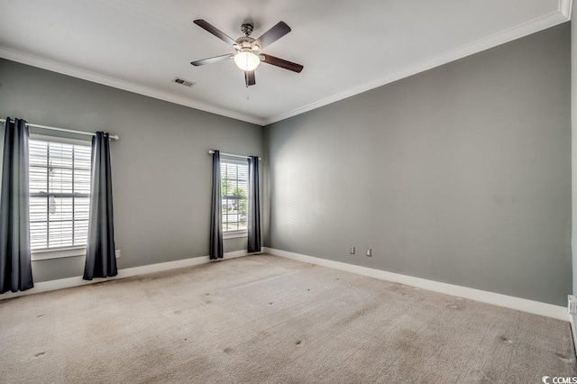carpeted empty room featuring crown molding, baseboards, and ceiling fan
