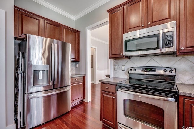 kitchen with stainless steel appliances, dark wood-style floors, ornamental molding, tasteful backsplash, and brown cabinetry
