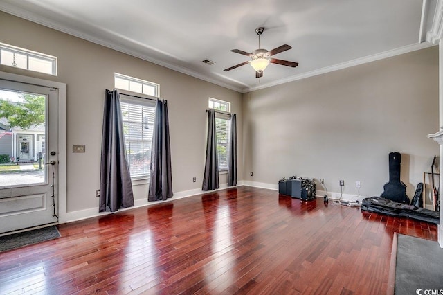 living room with ceiling fan, healthy amount of natural light, wood finished floors, and crown molding